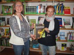 Kerstin Koob, Leiterin der Heppenheimer Stadtbücherei, freut sich über die Buchspende, die Sabine Knapp vom BUND Bergstraße überreicht hat. Foto: BUND Bergstraße